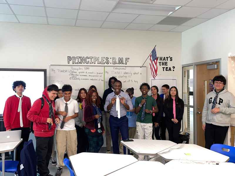 Students learning to tie ties in a classroom workshop