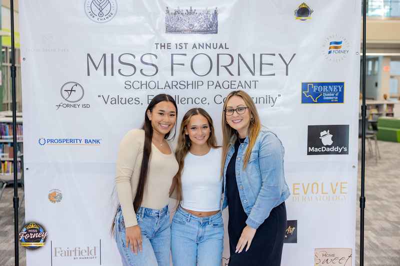 Attendees posing in front of the 1st Annual Miss Forney Scholarship Pageant step-and-repeat banner with sponsor logos