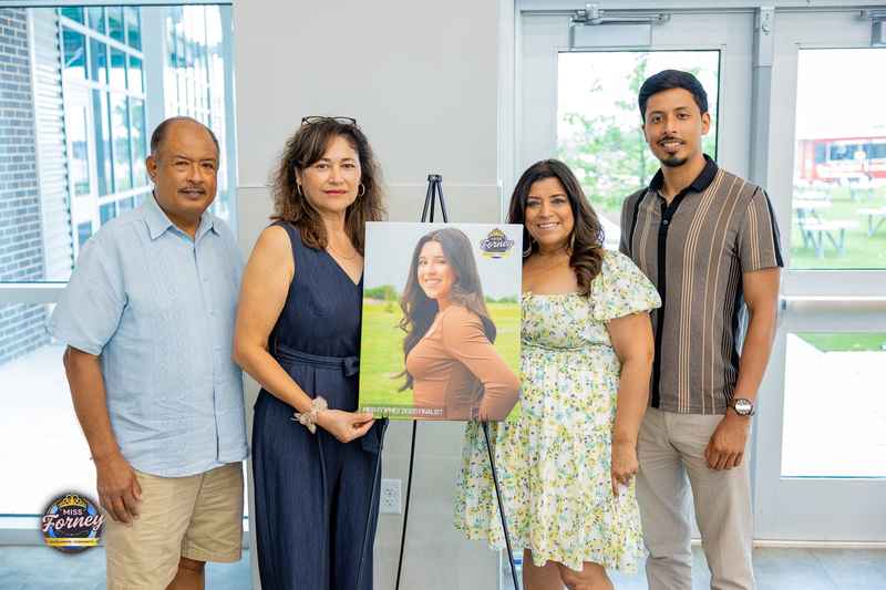 Four family members posing with a Miss Forney 2025 Finalist portrait on an easel